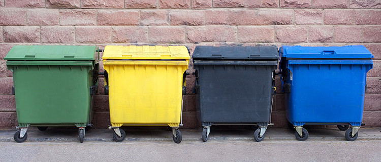 verschieden farbige (grün, gelb, schwarz, blau) Mülltonnen zur Abfalltrennung